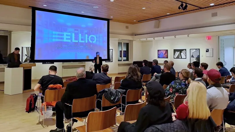 ELLIO cybersecurity presentation in modern conference room with audience seated in wooden chairs, large screen displaying company logo and tagline "We filter out therecon noise"